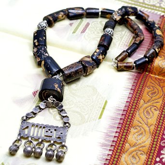 Stary amulet na sznurze czarnych korali